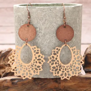 Detailed close-up of Bohemian hollow-out wood earrings with rustic lace pattern.