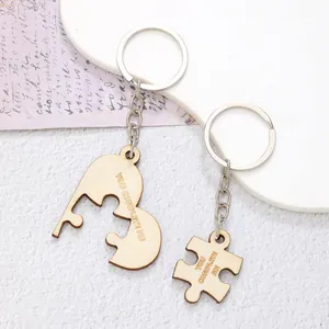 Close-up detail of wooden puzzle keychain set with engraved YOU COMPLETE ME text