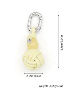 Detail view of cream handmade woven PU leather ball keychain with dimensions and weight.