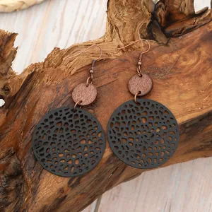 Détail de boucles d'oreilles pendantes vintage en cuir noir et bois faites main