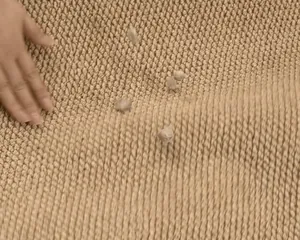 Primer plano de la textura tejida de una alfombra de entrada beige con efecto de sisal.