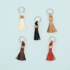 Handmade PU leather tassel keychain pendants in five colors on blue background