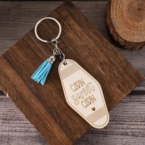 Vue détaillée d'un porte-clés en bois Cabin Sweet Cabin avec un gland bleu clair