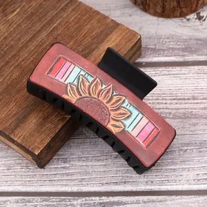 Detailopname van een haarklem in westernstijl met een leren zonnebloem-patroon