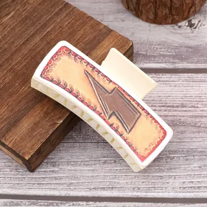 Detailopname van een westernstijl lederen haarklem met bliksemmotief op houten ondergrond