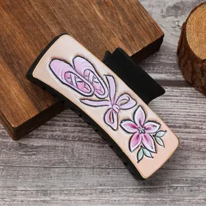 Close-up van een haarklem met elegante balletschoenen en een bloemrijke bloemenprint