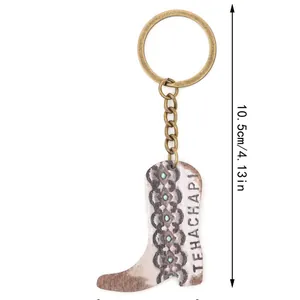 Llavero de bota de vaquero estilo western con medida de 10,5 cm sobre fondo blanco.