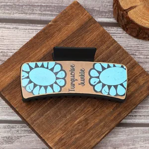 Vue détaillée de la pince à cheveux en cuir de style western avec motif de tournesol bleu.