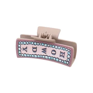 Haarklem in western-cowboystijl met Howdy-belettering op een roze decoratieve achtergrond