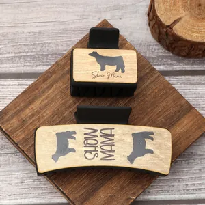 Detailed view of Western-style hair claws with cow print and Show Mama text labels