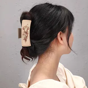 Vue détaillée d'une pince à cheveux en cuir style western avec imprimé vache sur cheveux