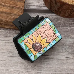 Gedetailleerde weergave van een haarclip met zonnebloem lederen design op rustiek houten blad