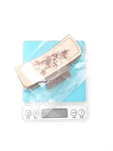 Pince à cheveux en cuir imprimé cactus western, mesure du poids affichant 29,8g.