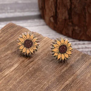 Detail view of sunflower pattern wooden stud earrings on rustic wood background