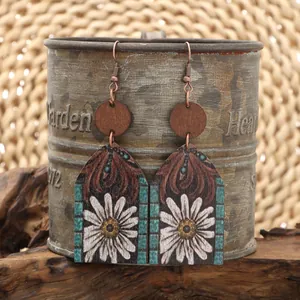 Close-up of western-style wooden earrings with daisy flower and tribal pattern