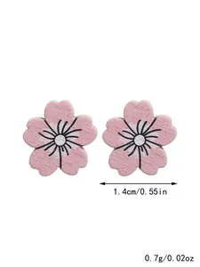 Detail of pink cherry blossom wooden stud earrings showing 1.4cm diameter size