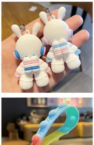 Close-up detail of cute white space rabbit astronaut keychains and colorful silicone wrist strap
