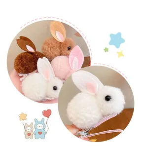 Dettaglio di un fermaglio per capelli a forma di coniglio di peluche bianco dalla trama soffice.