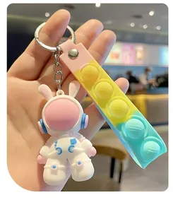 Close-up of a cute astronaut bunny keychain with a colorful silicone pop-it strap