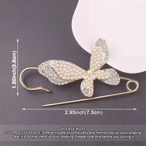 Macro detail of a gold butterfly safety pin brooch decorated with pearls and size labels
