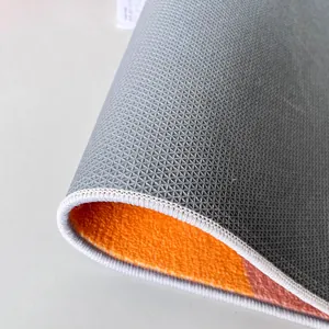 Close-up detail of the textured non-slip backing and orange pile surface of this vintage rug