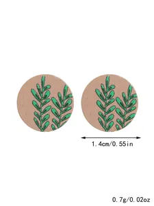Detail view showing size and weight of wooden stud earrings with leaf pattern design
