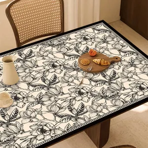 Dettaglio della tovaglia in pelle impermeabile con elegante motivo floreale bianco e nero.