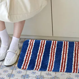 Gestreepte getufte absorberende vloermat op een decoratieve tegelvloer in een kamer