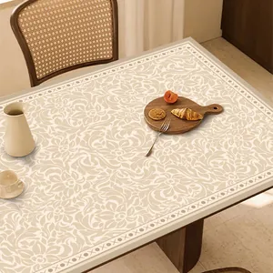 Dettaglio della tovaglietta in pelle beige a fiori con bordi decorativi su tavolo in legno