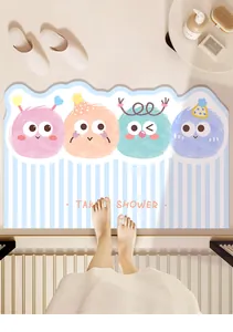 Close-up detail of a cute cartoon character bath mat featuring Take A Shower text design