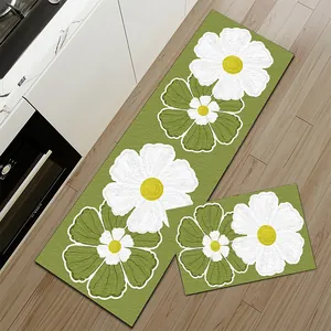 Detailweergave van florale keukenmatten op een houten vloer naast een witte kast.