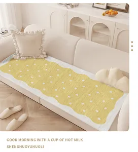 Close-up of yellow polka dot non-slip sofa mat on a minimalist cream fabric couch