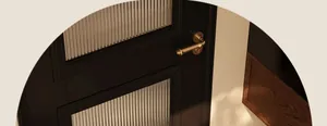 Primo piano della maniglia dorata su una porta in legno nero vintage con vetro scanalato