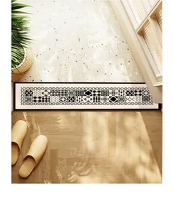 Détail d'un long tapis de seuil antidérapant aux motifs géométriques noir et blanc