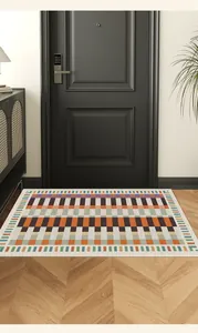 Geometric colorful pattern entry mat placed in front of a modern dark door for home décor.