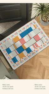 Modern geometric entryway rug on a light wood floor with a dark door background.