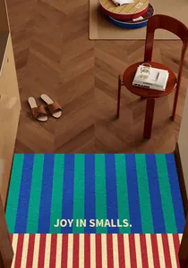 Vintage style blue and green striped PVC entry door mat in a cozy indoor setting
