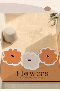 Macro view of a decorative floral doormat with Flowers text on light wooden flooring