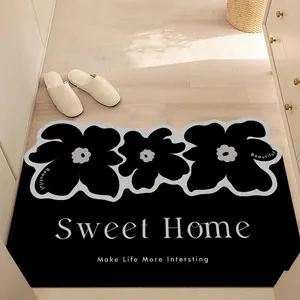 Modern black floral entry door mat with Sweet Home text on a light-colored wooden floor