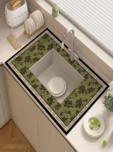 Close-up detail of an olive green floral absorbent leather mat placed on a modern kitchen countertop