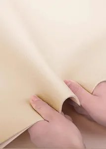 Gros plan détaillé montrant la texture épaisse du cuir crème d'un tapis de table imperméable.