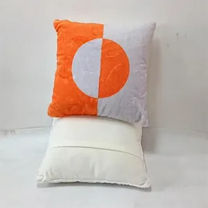 Detail of orange and grey geometric circular pattern cushion cover with white back view