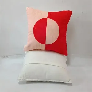 Detail view showing red and pink geometric pattern on soft square pillow cover