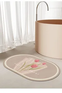 Vue détaillée du tapis de bain en terre de diatomée avec motif tulipes roses et texte.