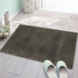 Thick dark brown shaggy door mat with absorbent cake velvet texture in a home doorway.