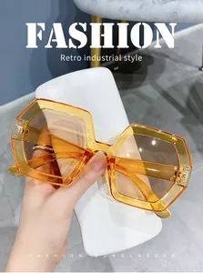 Detail view of oversized retro polygon sunglasses with irregular amber gradient lenses