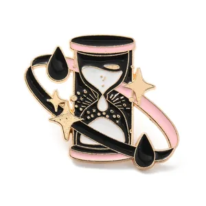 Detailed view of a cute cartoon hourglass enamel pin with pink dripping oil and gold stars