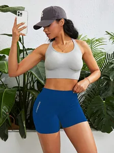 Frau in blauen High-Waist-Fitness-Shorts und grauem Sport-BH in einer Lifestyle-Umgebung.