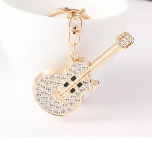 Exquisite close-up of a golden guitar keychain adorned with sparkling white rhinestones