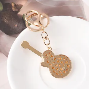 Creative gold metal electric guitar keychain with sparkling amber colored rhinestones.